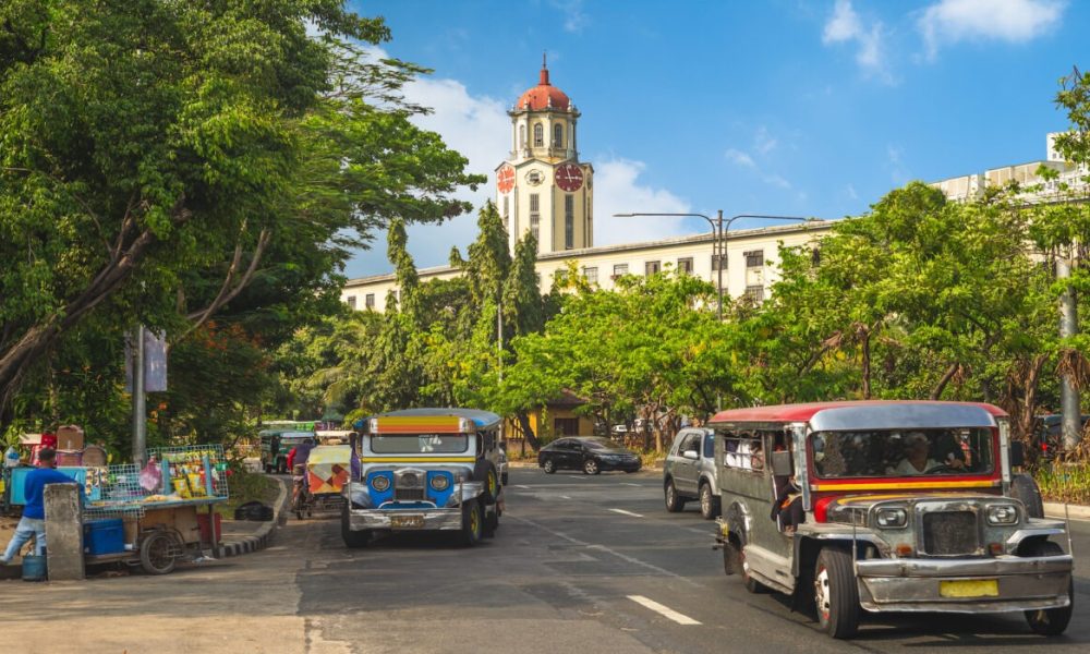 street view of manila with jeepney and clock tower